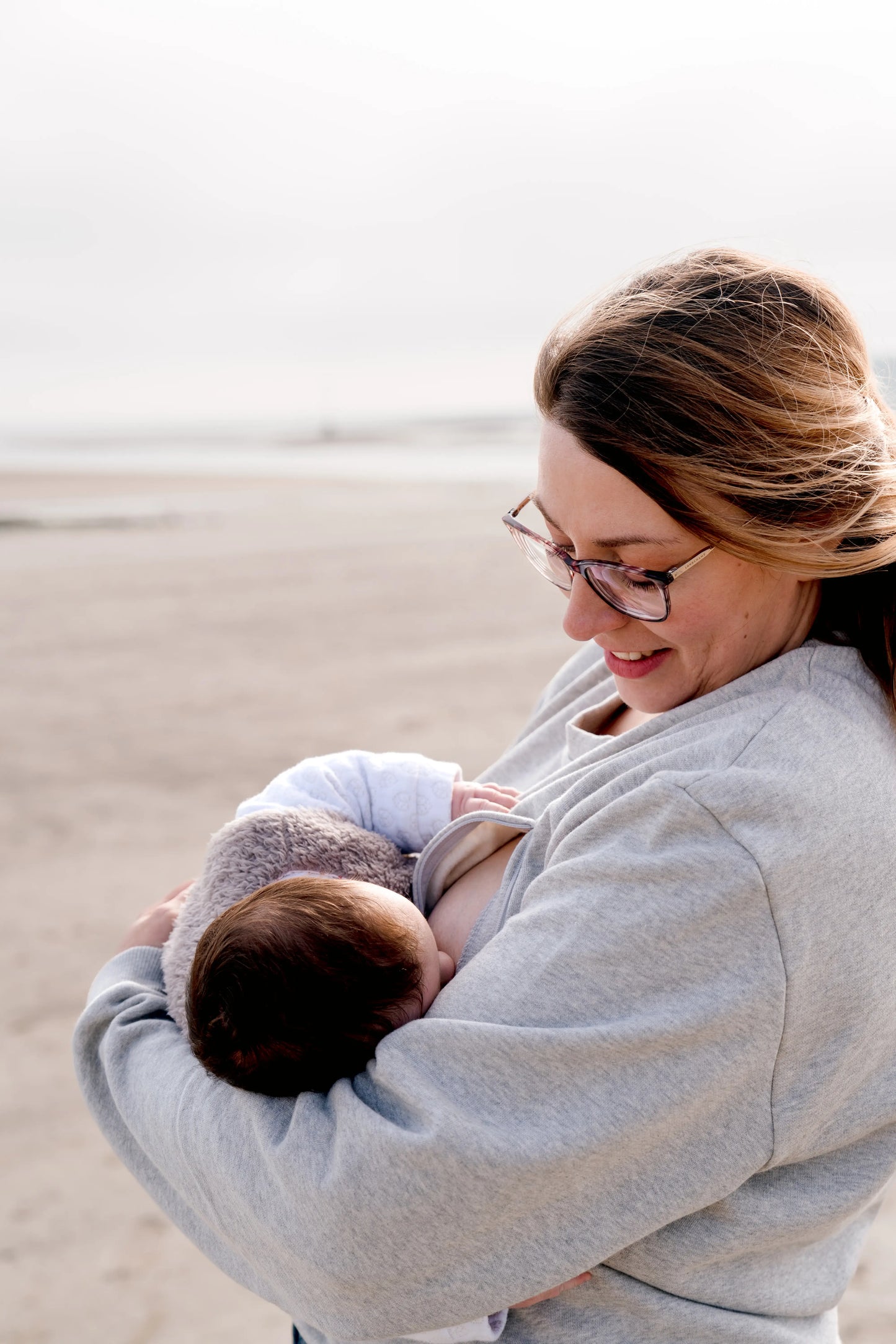 maman qui allaite partout, tout le temps, son bébé grâce à son sweat gris chiné en coton, brodé au coeur "Mon Coeur fait boob". Sweat d'inspiration des années 90s, est polyvalent et peut être porté par les futures mamans enceinte pendant leur grossesse et aussi après l'accouchement pour allaiter bébé. Deux zips de la marque YKK de chaque côté de la poitrine permettent d'accéder au sein et de nourrir facilement, simplement et discrètement votre bébé.