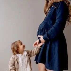 Robe bleu marine en gaze de coton pour la grossesse et l'allaitement grâce à sa coupe féminine et chic ainsi que ses longs zips YKK pour s'adapter à toutes les morphologies de mamans qui souhaitent allaiter pour nourrir leur bébé discrètement et facilement.