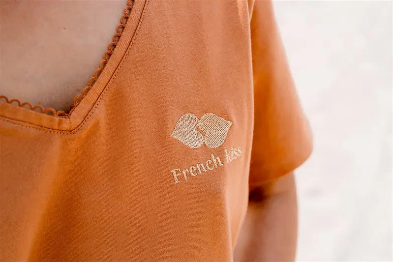 T-shirt Allaitement de couleur marron de la marque LIMKY. Le t-shirt possède des zips solides et discrets faciles à ouvrir d'une main. Pour un look maternité tendance et féminin le t-shirt possèdes une broderie au coeur "French Kiss" ainsi qu'un décolleté col V avec de la fine dentelle ainsi qu'un décolleté V dans le dos pour un effet dos nu.