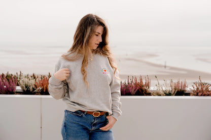 maman qui est habillé de son sweat maternité gris chiné en coton, brodé au coeur "Mon Coeur fait boob". Sweat d'inspiration des années 90s, est polyvalent et peut être porté par les futures mamans enceinte pendant leur grossesse et aussi après l'accouchement pour allaiter bébé. Deux zips de la marque YKK de chaque côté de la poitrine permettent d'accéder au sein et de nourrir facilement, simplement et discrètement votre bébé. Un sweat moderne, tendance grâce à sa coupe loose confortable féminine