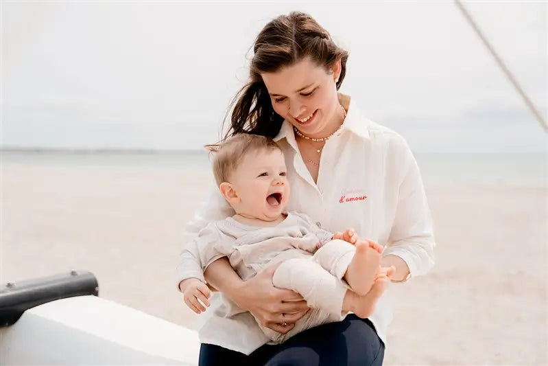 Chemisier de Grossesse et Allaitement "Crème d'Amour" de la marque LIMKY. Une blouse chemisier de couleur crème, pour accompagner maman à chaque étape de sa maternité, dotée de zips discrets et solides pour faciliter l'allaitement de bébé. Une coupe flatteuse, un tissu absorbant en gaze de coton, avec une jolie broderie au coeur "crème d'amour". Idéal en cas de petite fuite de lait maternel. Un cadeau de naissance chic et idéal pour les jeunes et futures mamans qui fêtent leur baby shower !