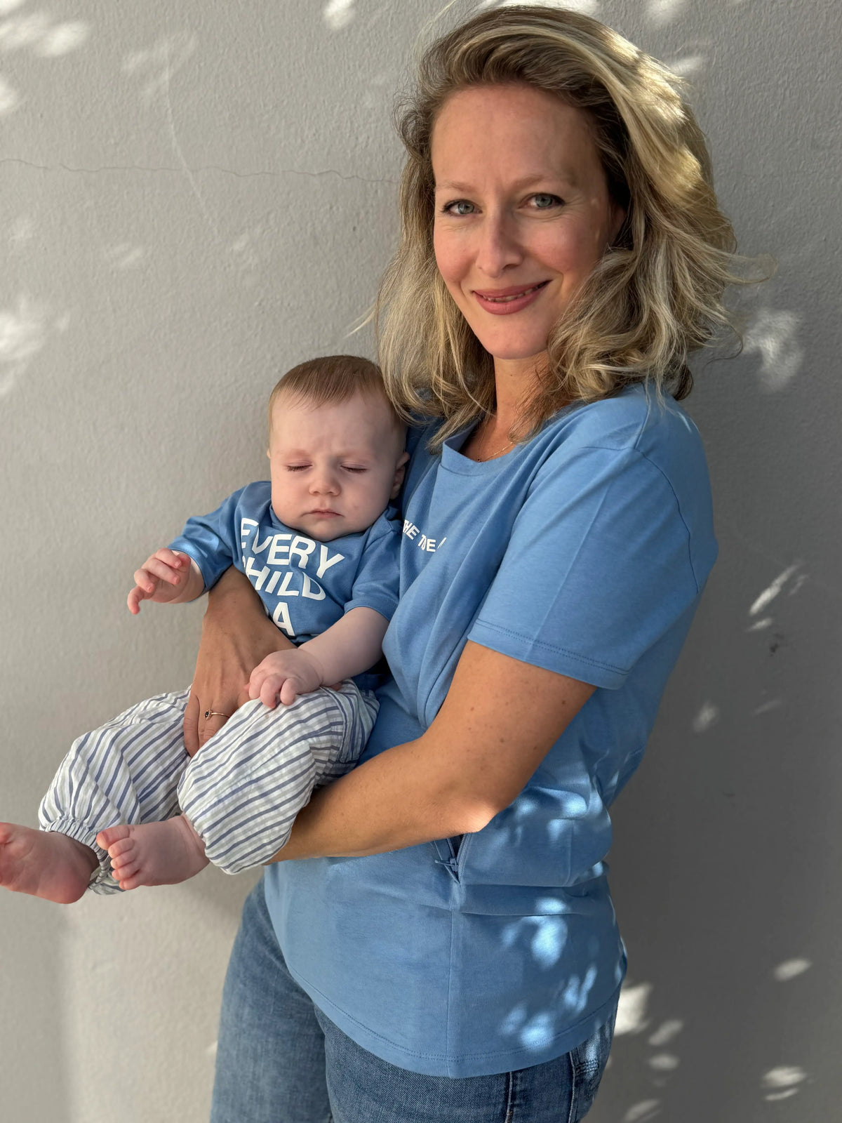 T-shirt d'allaitement LIMKY en coton bleu ciel, imprimé "tue true artist" avec des zips de chaque côté qui s'ouvrent facilement à une seule main. Modèle assorti pour bébé "Every child is a masterpiece".