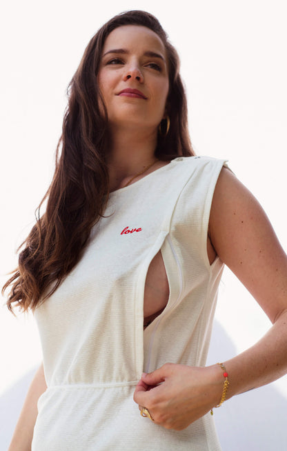 Robe d'allaitement blanche LIMKY, en coton et fabriqué au Portugal.
Cette robe avec un décolleté V dans le dos pour un dos nu est brodé au coeur "Love".
Cette robe maternité possède des longs zips solides, discrets et faciles à ouvrir d'une seule main pour nourrir bébé au sein rapidement, facilement et discrètement.
Un vêtement d'allaitement de qualité que les mamans auront plaisir à porter même après le post-partum. Une idée cadeau de naissance idéale à offrir pour une baby shower.