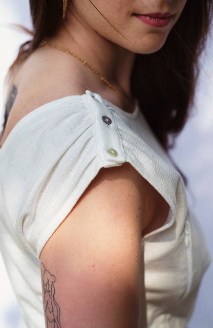 Robe d'allaitement blanche LIMKY, en coton et fabriqué au Portugal.
Cette robe avec un décolleté V dans le dos pour un dos nu est brodé au coeur "Love".
Cette robe maternité possède des longs zips solides, discrets et faciles à ouvrir d'une seule main pour nourrir bébé au sein rapidement, facilement et discrètement.
Un vêtement d'allaitement de qualité que les mamans auront plaisir à porter même après le post-partum. Une idée cadeau de naissance idéale à offrir pour une baby shower.