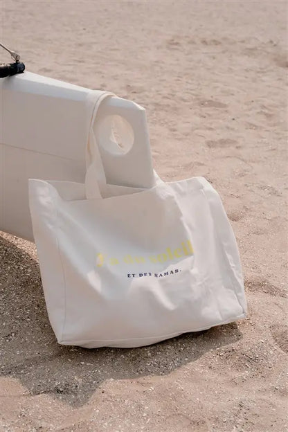 Sac à Langer  ou cabas XXL LIMKY. Ce fourre-tout en toile de coton est printé "Y'a du Soleil et des Mamas" pour un joli jeu de mot ensoleillé et vous accompagner pour toutes vos sorties : plage, bureau, ville, parc. Son format XXL permet à ce sac de contenir tous vos essentiels et indispensables de jeune maman de bébé.