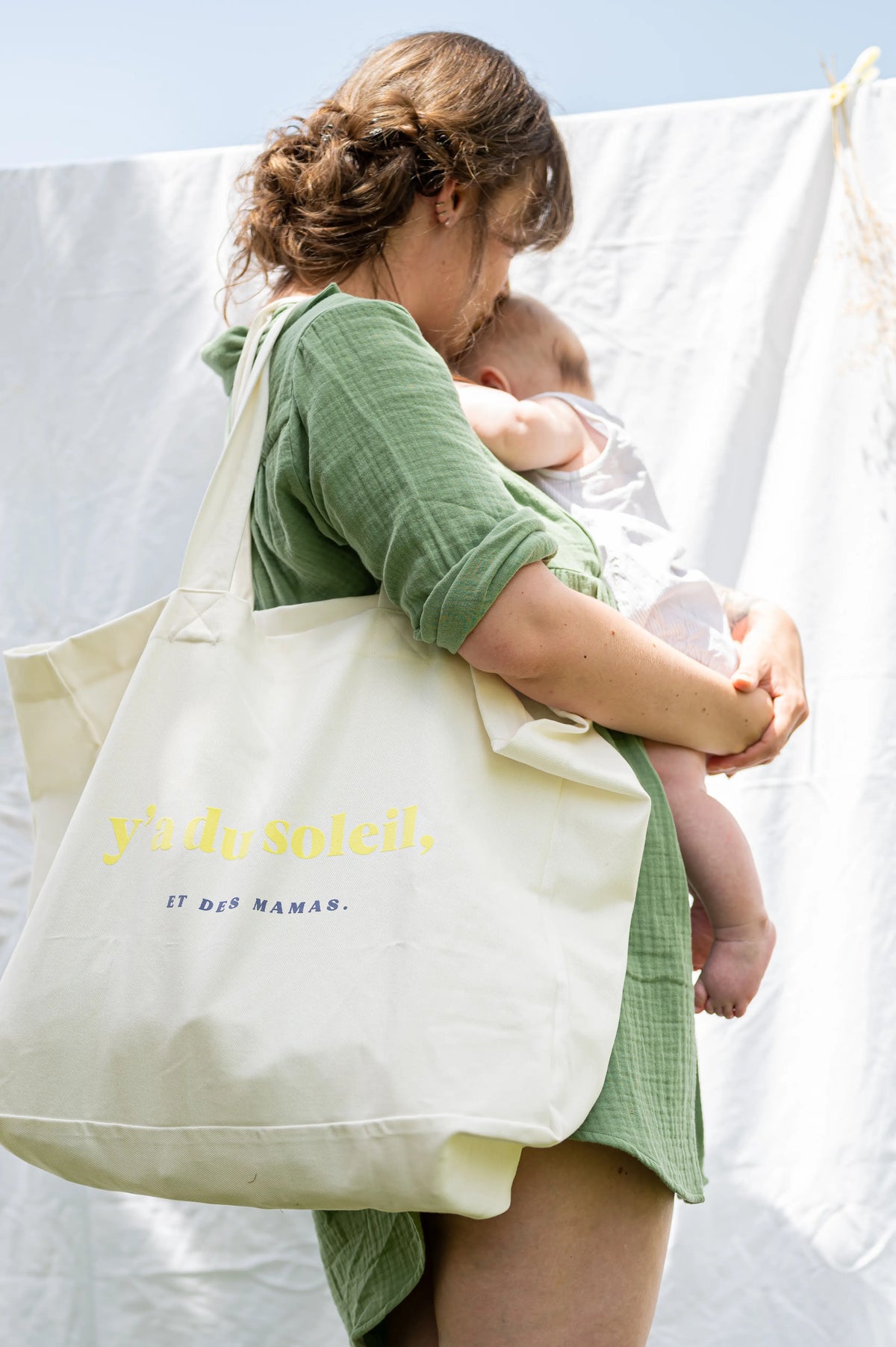 Sac à Langer  ou cabas XXL LIMKY. Ce fourre-tout 100% twill de coton est printé "Y'a du Soleil et des Mamas" pour un joli jeu de mot ensoleillé et vous accompagner pour toutes vos sorties : plage, bureau, ville, parc. Son format XXL permet à ce sac de contenir tous vos essentiels et indispensables de jeune maman de bébé.
