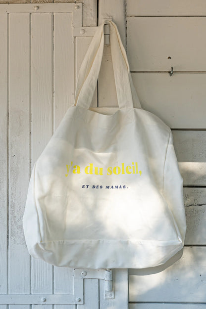 Sac à Langer  ou cabas XXL LIMKY. Ce fourre-tout 100% twill de coton est printé "Y'a du Soleil et des Mamas" pour un joli jeu de mot ensoleillé et vous accompagner pour toutes vos sorties : plage, bureau, ville, parc. Son format XXL permet à ce sac de contenir tous vos essentiels et indispensables de jeune maman de bébé.