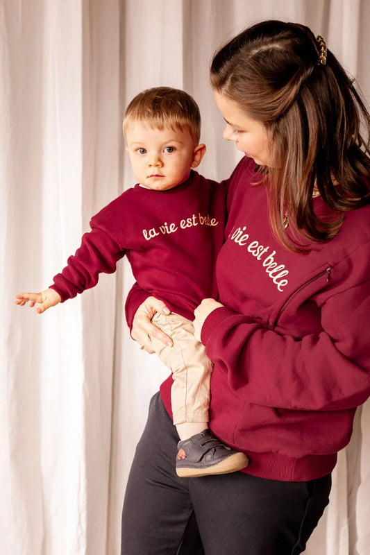 Sweat Grossesse et Allaitement "La Vie Est Belle" en coton de couleur rouge bordeaux. Comprend des glissières avec zips solides et discrets faciles à ouvrir d'une seule main pour allaiter bébé.