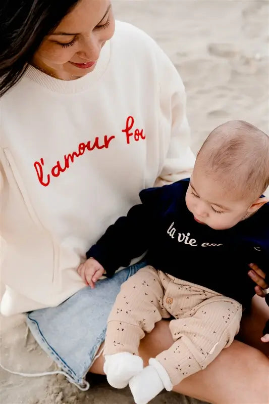 Sweat de Grossesse et Allaitement  LIMKY "L'Amour Fou". En coton, et doté de zips solides, discrets et faciles à ouvrir d'une seule main. Ce pull maternité de couleur crème est brodé "l'amour fou" en rouge. Sa coupe polyvalente et confortable donne un look tendance aux jeunes et futures mamans. Un vêtement maternité de qualité qui accompagne pendant la grossesse et l'allaitement, une idée de cadeau de naissance idéale pour sa liste de naissance ou une baby shower !