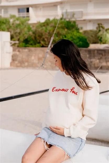 Sweat de Grossesse et Allaitement  LIMKY "L'Amour Fou". En coton, et doté de zips solides, discrets et faciles à ouvrir d'une seule main. Ce pull maternité de couleur crème est brodé "l'amour fou" en rouge. Sa coupe polyvalente et confortable donne un look tendance aux jeunes et futures mamans. Un vêtement maternité de qualité qui accompagne pendant la grossesse et l'allaitement, une idée de cadeau de naissance idéale pour sa liste de naissance ou une baby shower !