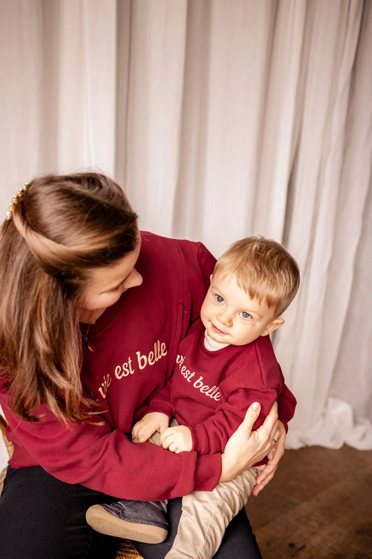Sweat Grossesse et Allaitement "La Vie Est Belle" en coton de couleur rouge bordeaux. Comprend des glissières avec zips solides et discrets faciles à ouvrir d'une seule main pour allaiter bébé.