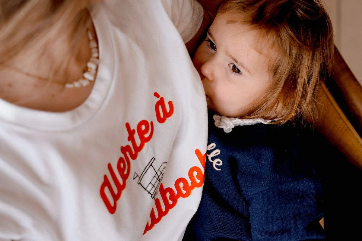 T-shirt d'allaitement blanc LIMKY "Alerte à Maliboob" en coton.
 Ce t-shirt au col rond est 100% coton et est fabriqué au Portugal.
Cet t-shirt maternité spécialement conçu pour faciliter l'allaitement, possède des longs zips solides et faciles à ouvrir d'une seule main pour nourir bébé au sein discrètement.
Un t-shirt original, tendance et de qualité que les mamans auront plaisir à porter même après le post-partum. Une idée cadeau de naissance idéale à offrir pour une baby shower.