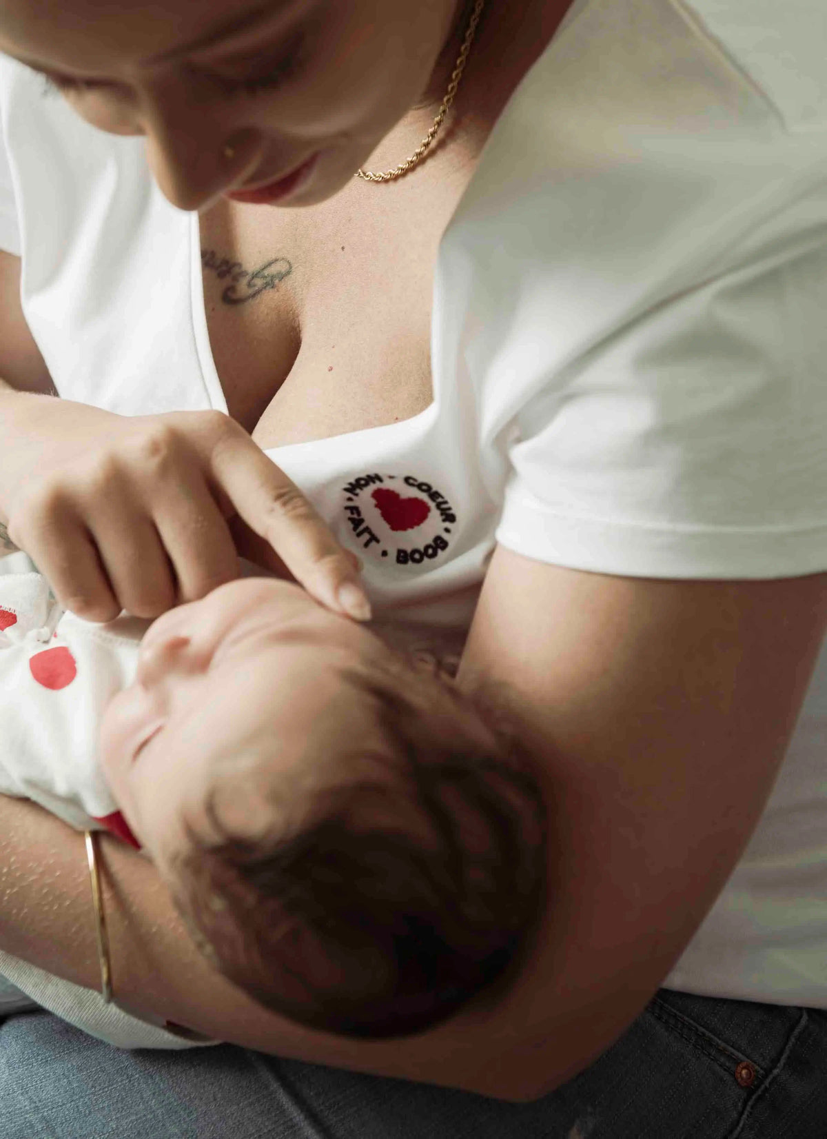 T-shirt d'allaitement en coton blanc de la marque LIMKY avec un décolleté col V.
Un t-shirt d'allaitement doté de zips solides, discrets, et faciles à ouvrir d'une seule main pour que les mamans puissent allaiter discrètement et facilement bébé. Le t-shirt d'allaitement possède une broderie au coeur "mon coeur fait boob". Fabriqué au Portugal et de qualité, c'est une idée de cadeau de naissance idéale lors du baby shower !