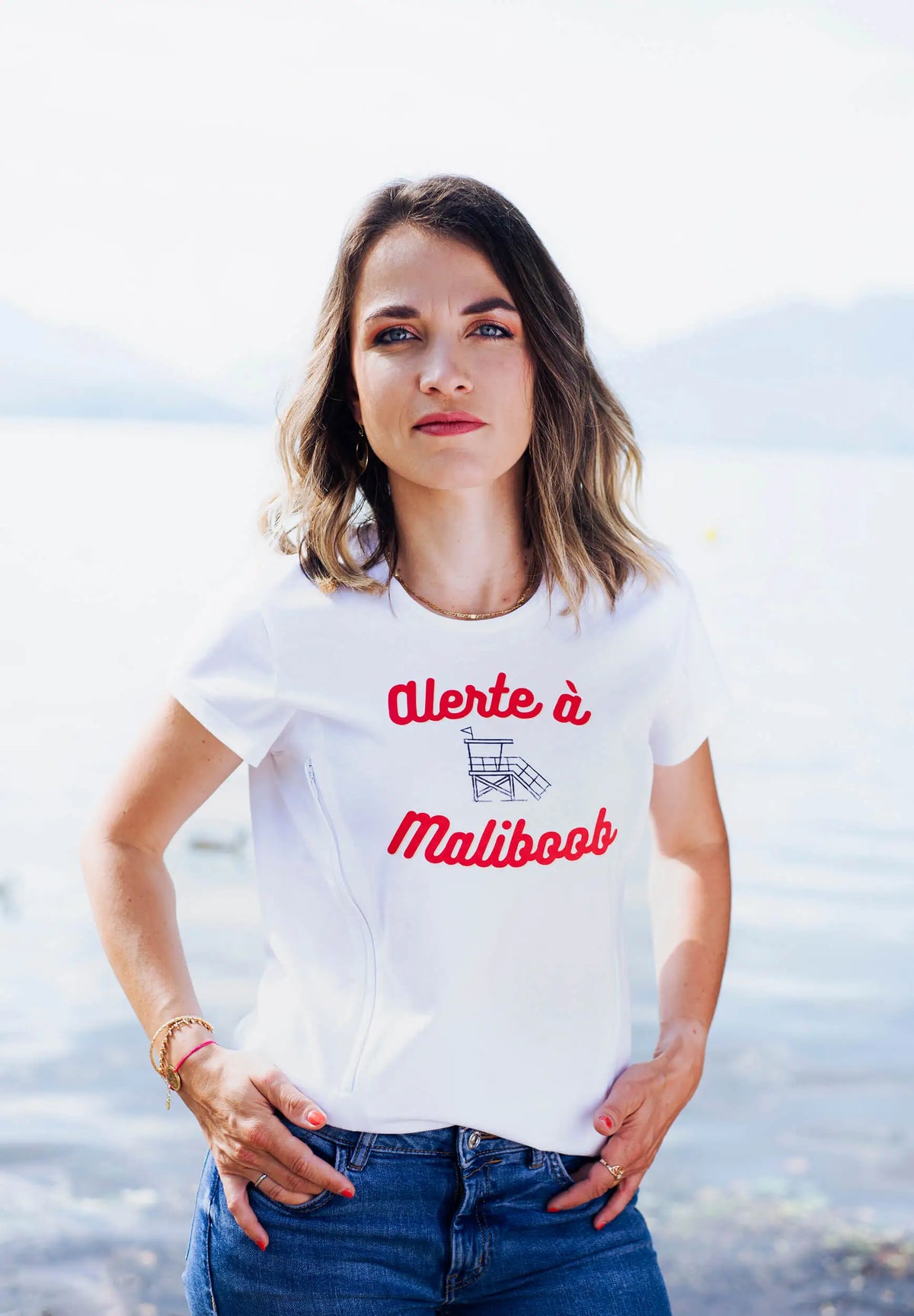 T-shirt d'allaitement blanc LIMKY "Alerte à Maliboob" en coton.
 Ce t-shirt au col rond est 100% coton et est fabriqué au Portugal.
Cet t-shirt maternité spécialement conçu pour faciliter l'allaitement, possède des longs zips solides et faciles à ouvrir d'une seule main pour nourir bébé au sein discrètement.
Un t-shirt original, tendance et de qualité que les mamans auront plaisir à porter même après le post-partum. Une idée cadeau de naissance idéale à offrir pour une baby shower.