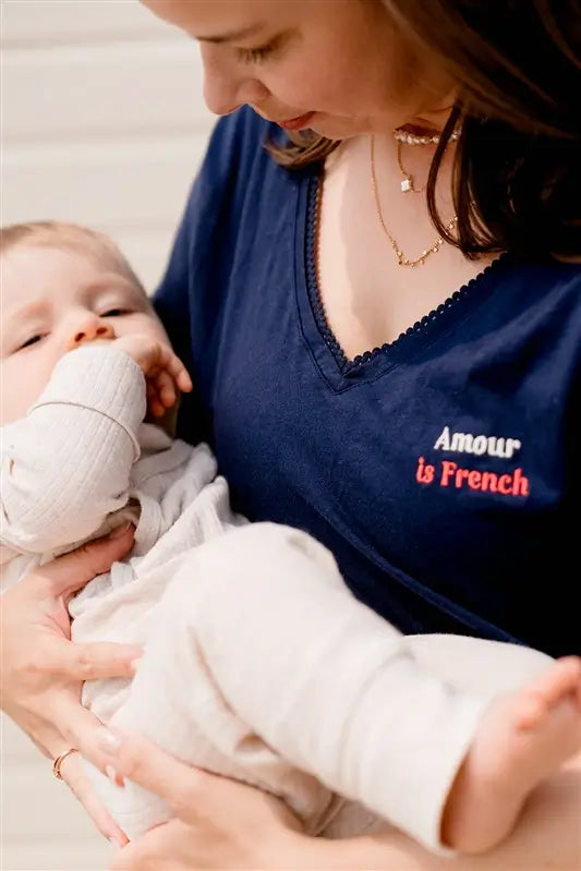 T-shirt d'allaitement LIMKY en coton, avec une encolure en décolleté col V avec de la fine dentelle. Ce t-shirt d'allaitement propose des glissières avec des zips pour allaiter facilement et discrètement bébé. Le t-shirt possède également une jolie broderie au coeur "Amour is French".