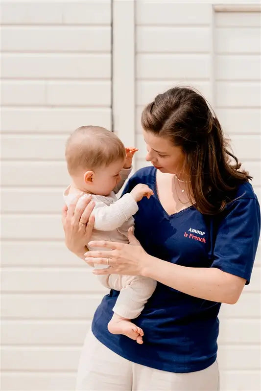 T-shirt d'allaitement LIMKY en coton, avec une encolure en décolleté col V avec de la fine dentelle. Ce t-shirt d'allaitement propose des glissières avec des zips pour allaiter facilement et discrètement bébé. Le t-shirt possède également une jolie broderie au coeur "Amour is French".