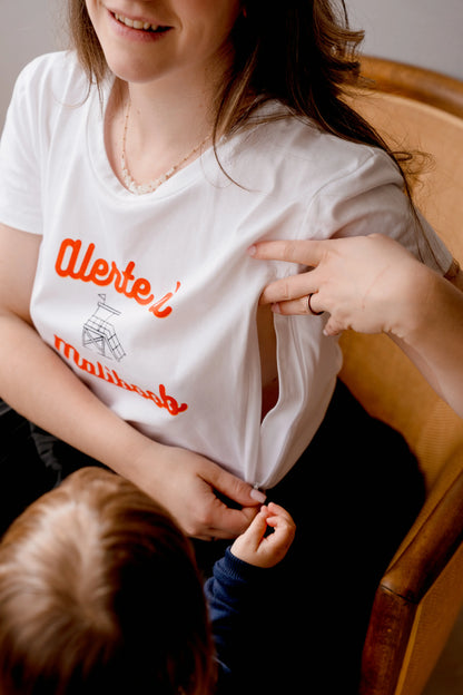 T-shirt d'allaitement blanc LIMKY "Alerte à Maliboob" en coton.
 Ce t-shirt au col rond est 100% coton et est fabriqué au Portugal.
Cet t-shirt maternité spécialement conçu pour faciliter l'allaitement, possède des longs zips solides et faciles à ouvrir d'une seule main pour nourir bébé au sein discrètement.
Un t-shirt original, tendance et de qualité que les mamans auront plaisir à porter même après le post-partum. Une idée cadeau de naissance idéale à offrir pour une baby shower.
