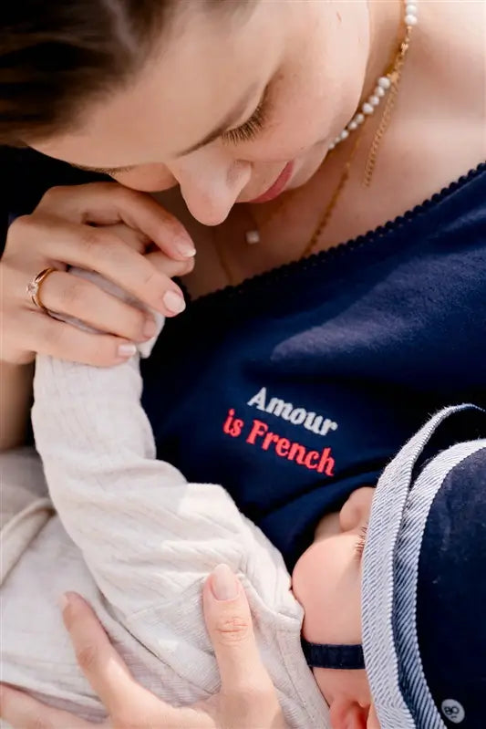 T-shirt d'allaitement LIMKY en coton, avec une encolure en décolleté col V avec de la fine dentelle. Ce t-shirt d'allaitement propose des glissières avec des zips pour allaiter facilement et discrètement bébé. Le t-shirt possède également une jolie broderie au coeur "Amour is French".